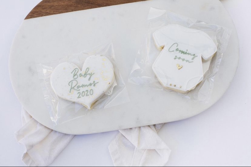 heart and baby onesie cookie design with baby announcement on cookies