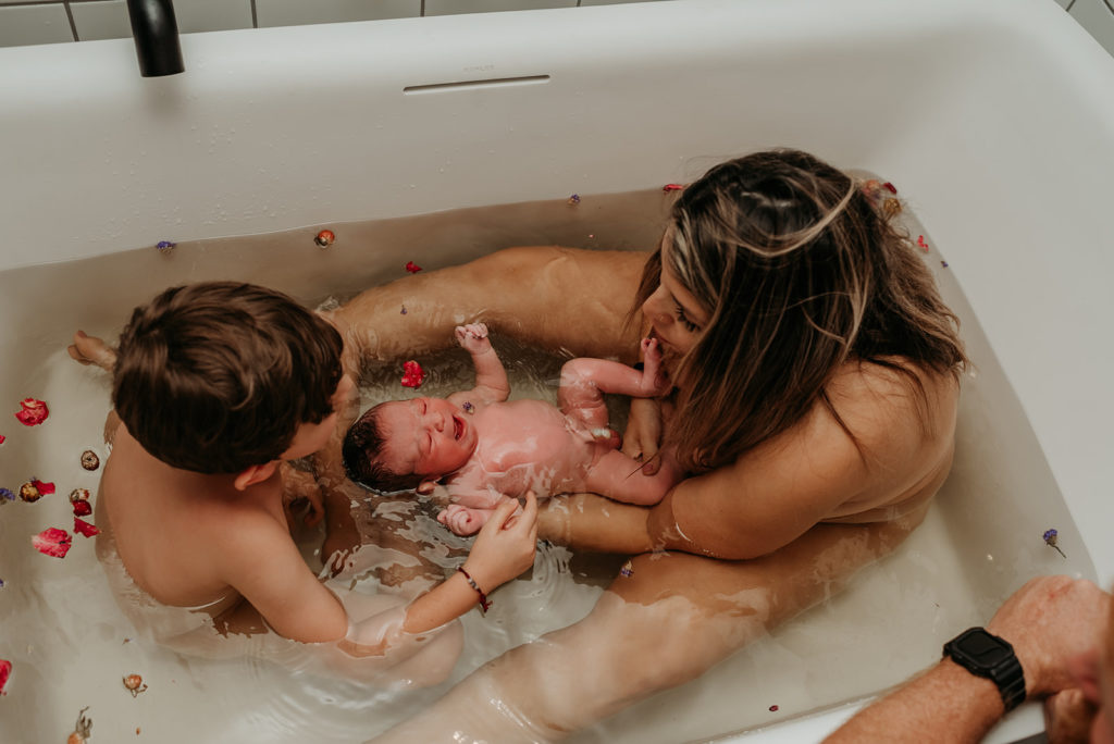 mom, son and new born in herbal bath after birth